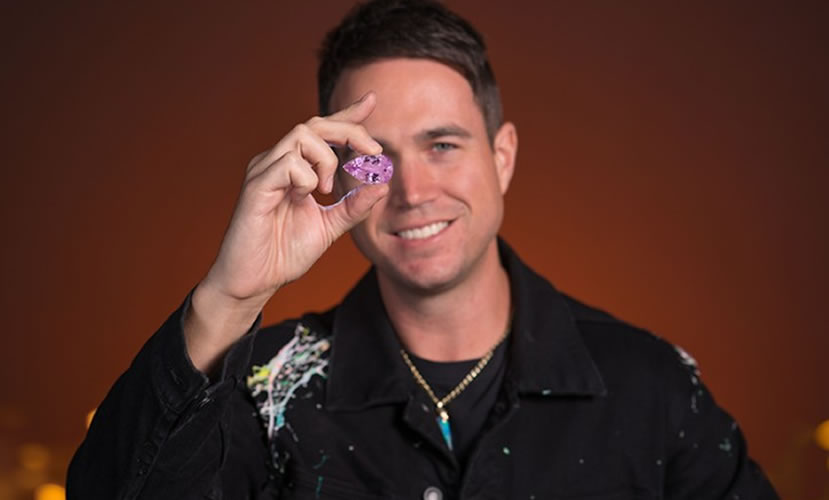 Josh Mulrine holding up a pink gemstone