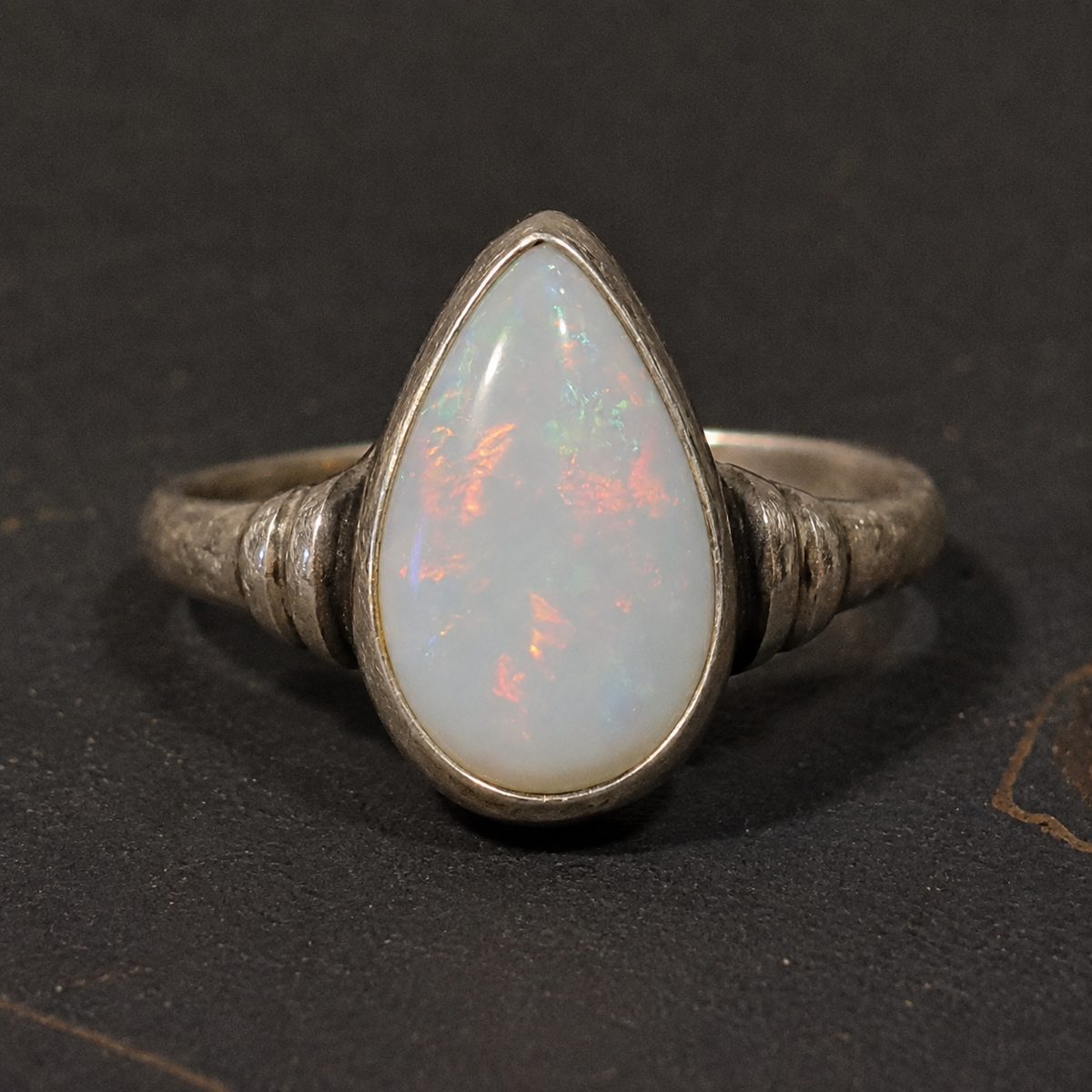 Pear-shaped white opal ring showing flash of colour, opal valuation Canberra