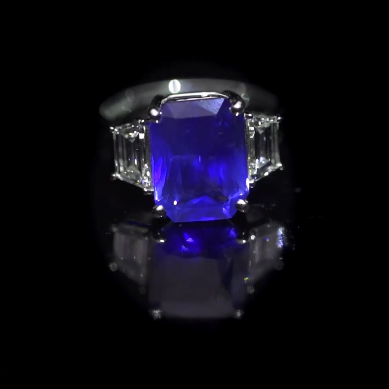 Emerald-cut blue sapphire ring with trapezoid side diamonds