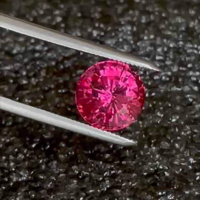 Round 3.58ct pinkish red Burma spinel in tweezers, loupe clean